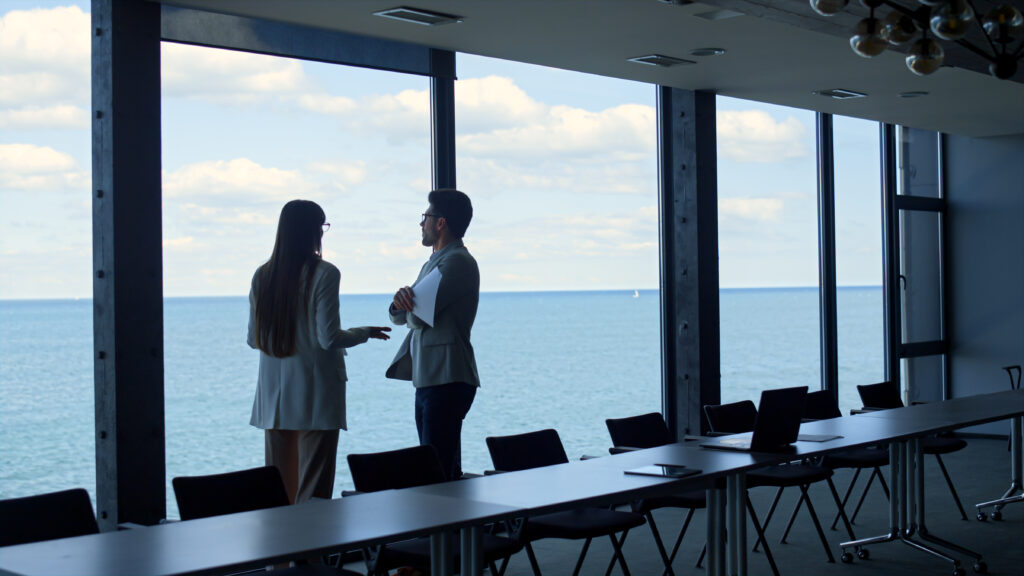 Financial managers discussing contract at panorama window. Business team argue